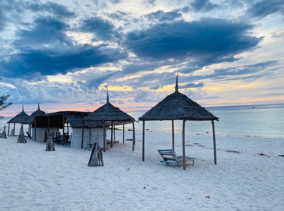 Paillotes sur la plage d'Ambola au coucher du soleil