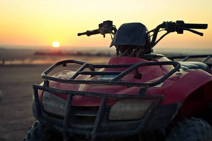 Quad à l'arrêt face au coucher de soleil